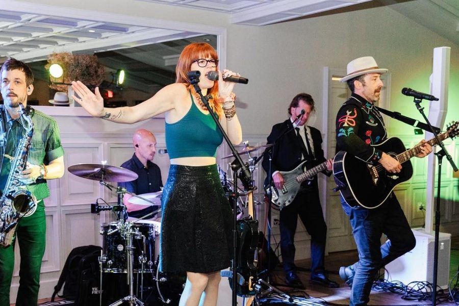 DJ band hybrid performing at a wedding reception with live violin, guitar, drums, and DJ.