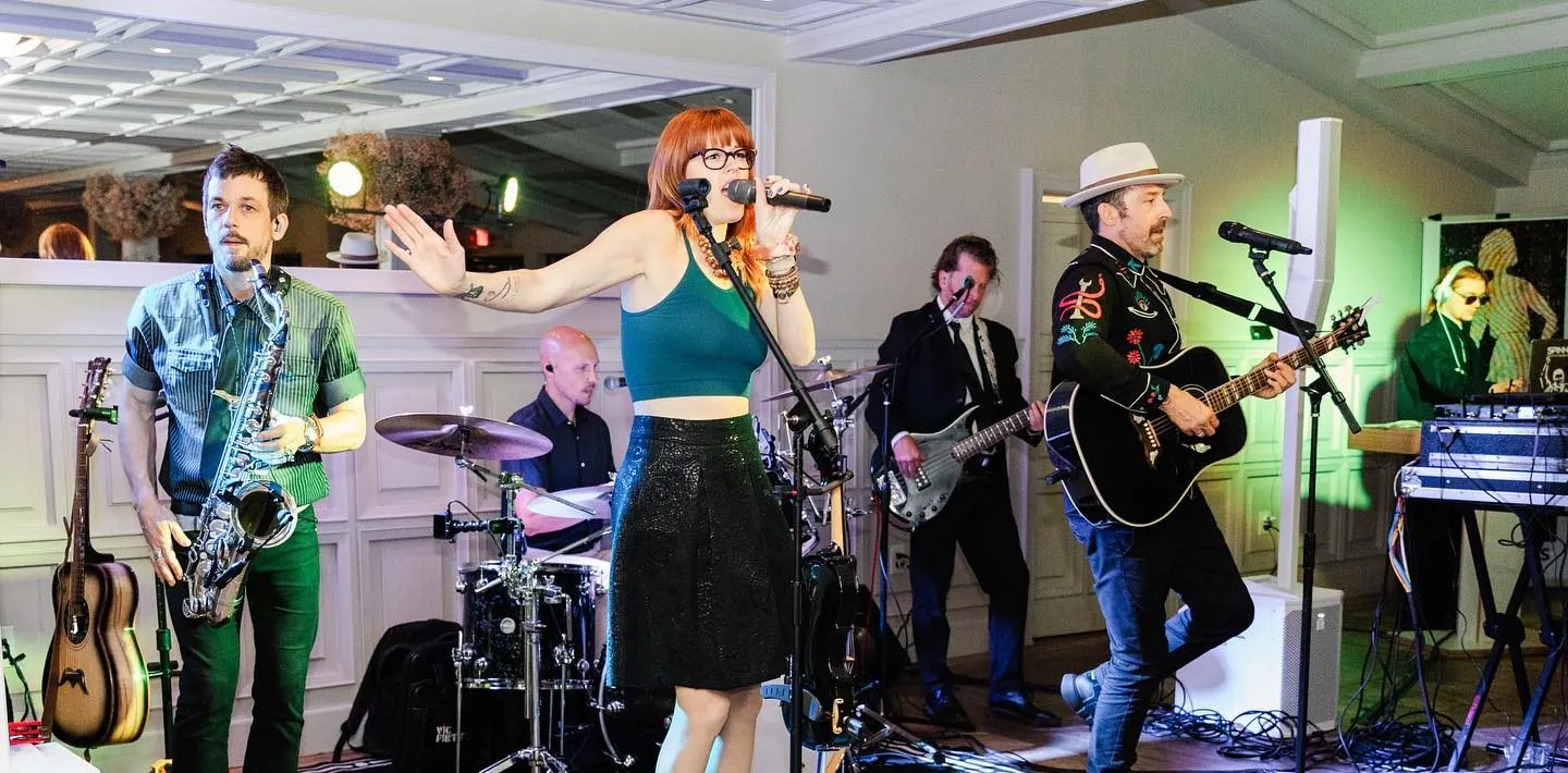 DJ band hybrid performing at a wedding reception with live violin, guitar, drums, and DJ.